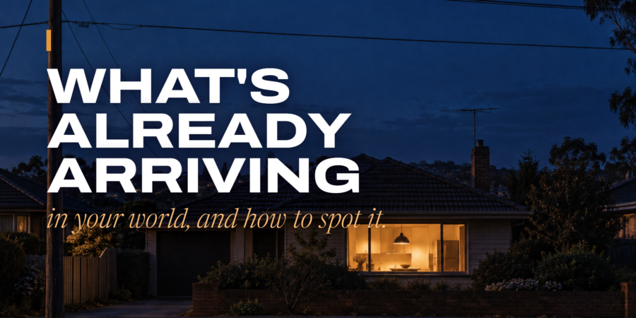 A suburban house at dusk with one warm kitchen window lit